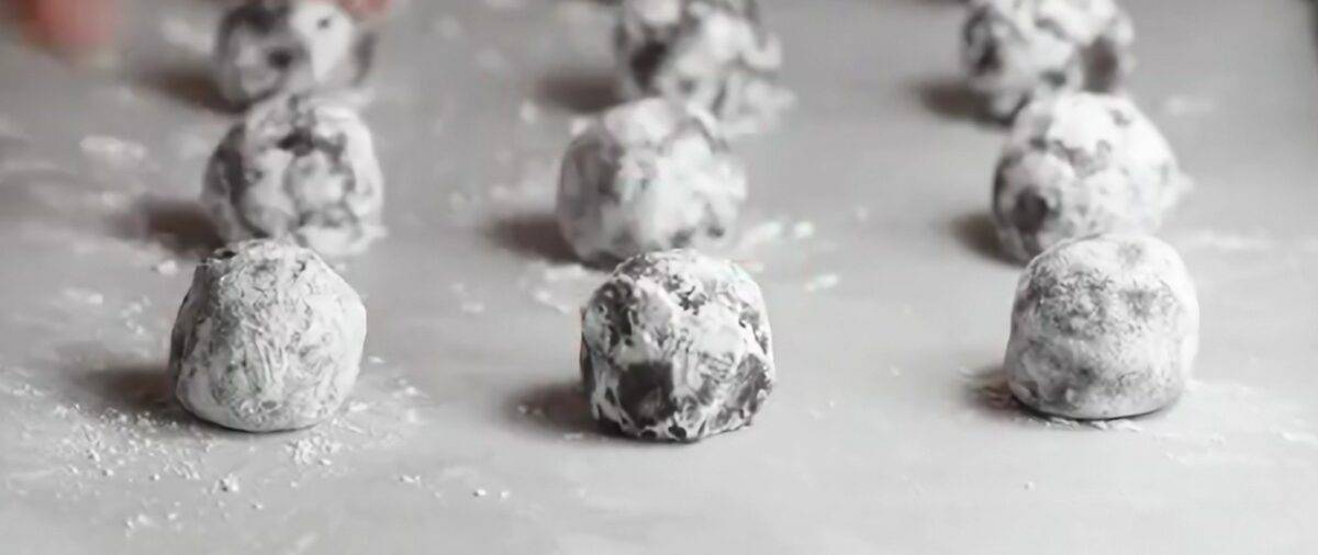 Rolo cookies coated in powdered sugar on a cookie sheet.