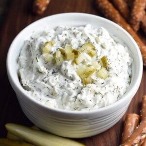 dill pickle dip in small dish with diced pickles on top