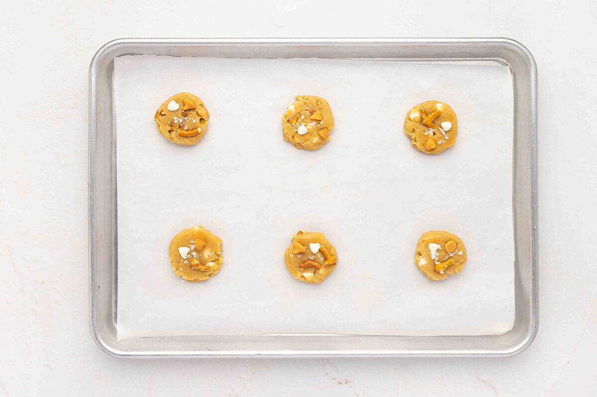Balls of butterscotch pretzel cookie dough on a baking sheet