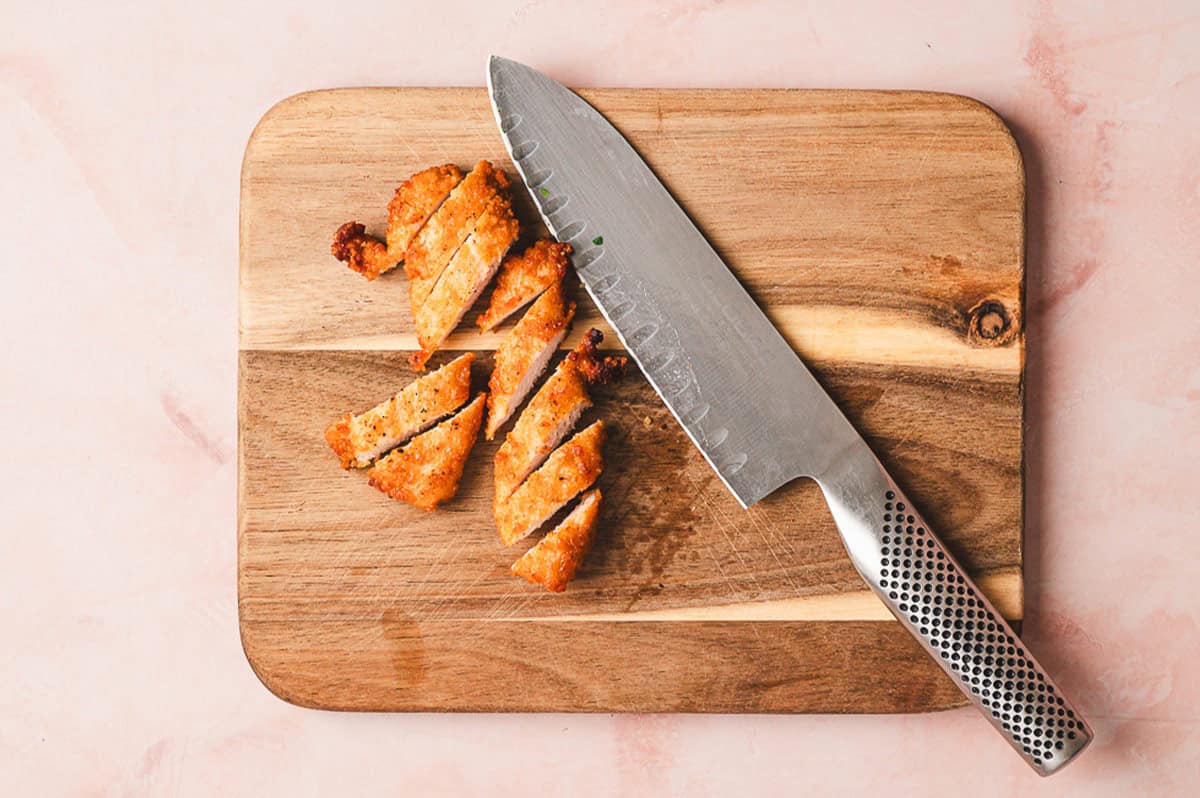 Breaded chicken strips sliced on a cutting board
