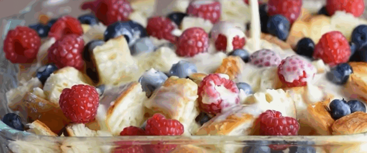 Pouring the custard over the torn up croissants and fruit.