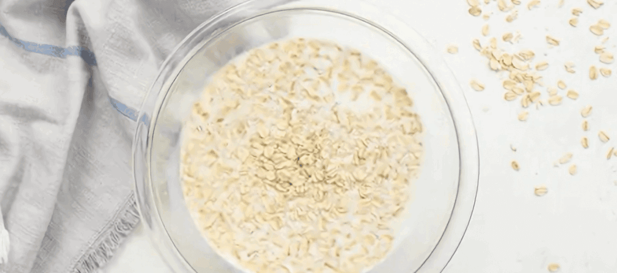 Oats soaking in milk in a glass bowl.