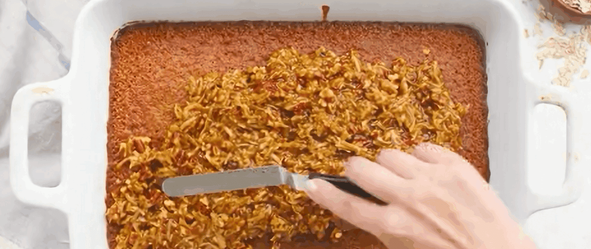 Spreading the streusel topping over the baked cake.