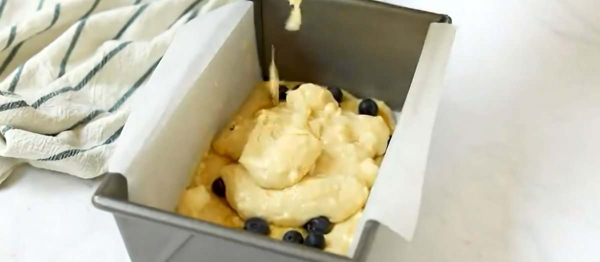 Layering the batter with lemon curd and blueberries.