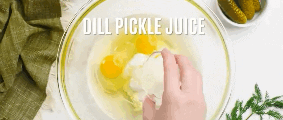 Combining the wet ingredients to make dill pickle bread in a glass bowl.