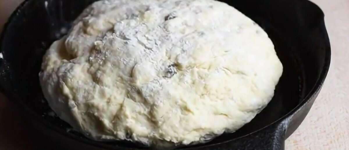 Shaped dough in a cast iron skillet.