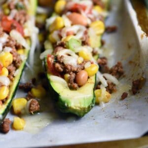 Taco Zucchini Boats are hollowed out zucchini, stuffed with all your favorite taco ingredients. Gluten free and healthy, these make a delicious appetizer, side dish, or main meal! #StuffedZucchini #ZucchiniBoats #tacos #glutenfree