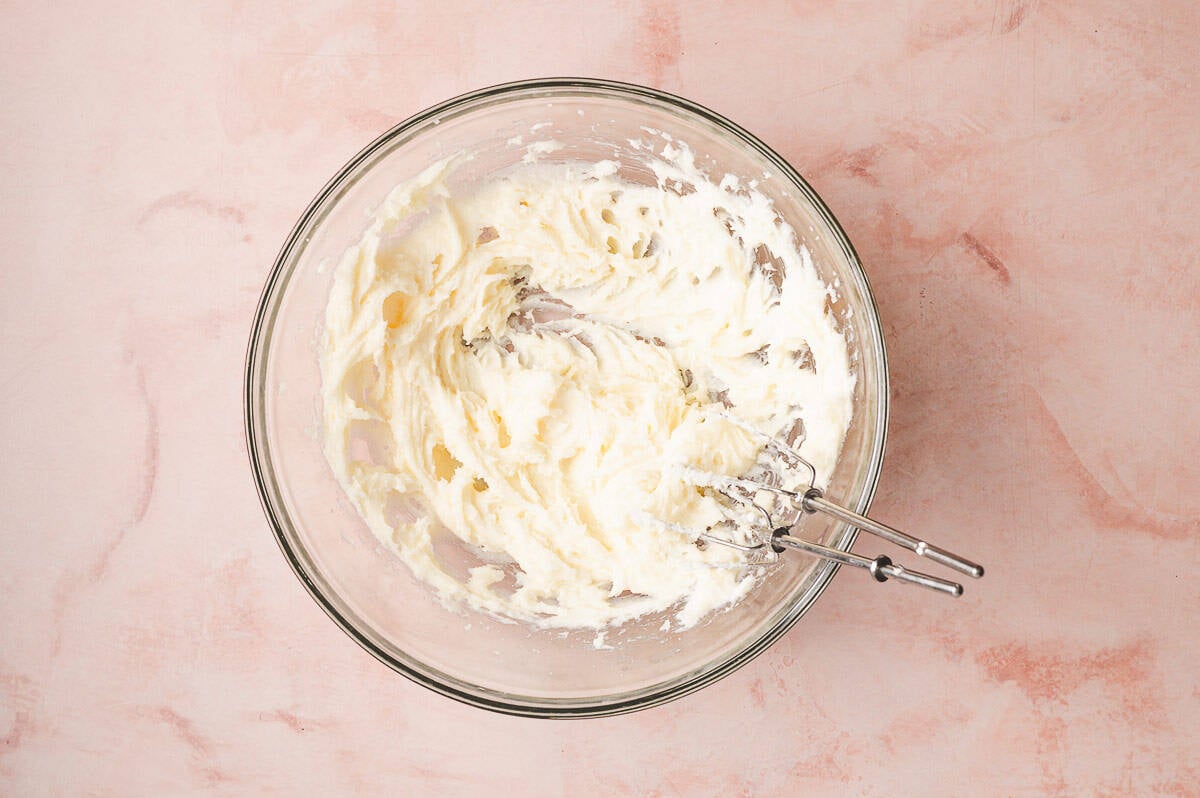 This Coconut Cream Lush is smooth, rich, light, and there’s no cooking involved. It’s so easy and perfect for summer gatherings! Beating cream cheese in a bowl
