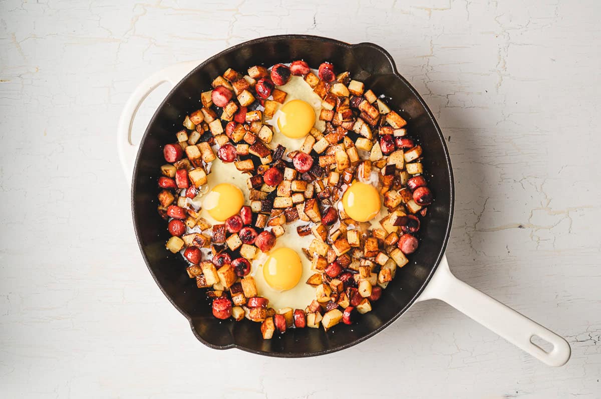 Smoked sausage, diced potatoes, egg, and cheese make this Skillet Breakfast Hash an easy, savory, and hearty breakfast. Eggs in a cast iron skillet with potatoes and sausage