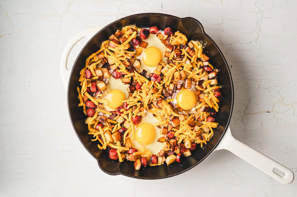 Smoked sausage, diced potatoes, egg, and cheese make this Skillet Breakfast Hash an easy, savory, and hearty breakfast. Overhead view of skillet breakfast hash
