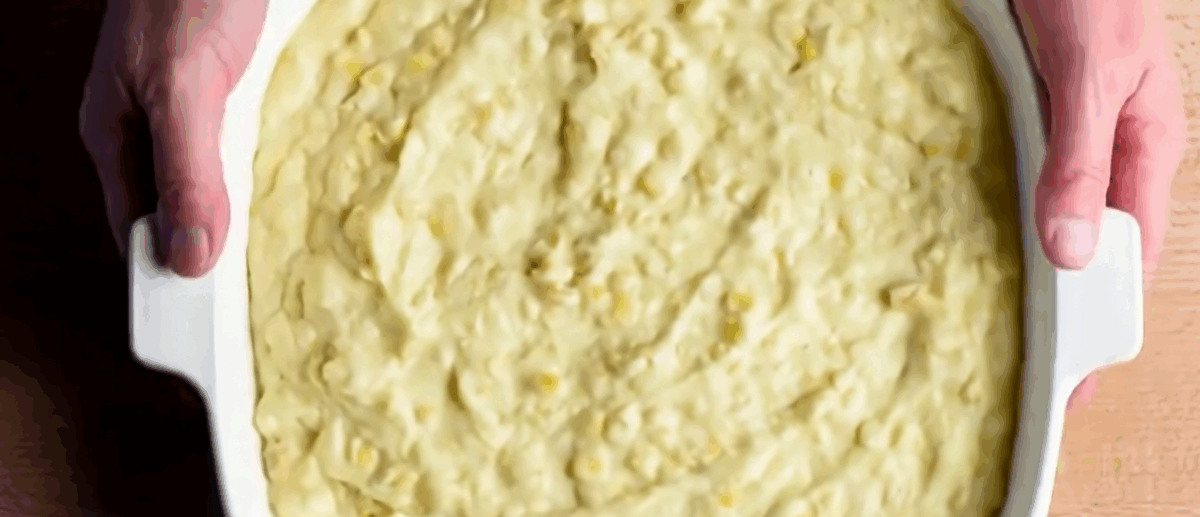 Cornbread batter in a white baking dish.