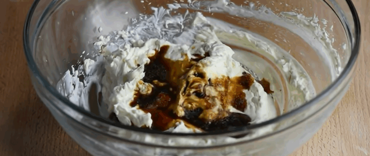 Combining the ingredients to make crab Rangoon in a glass bowl. 