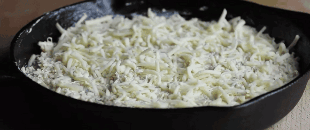 All the ingredients to make crab Rangoon in a black skillet ready for the oven. 