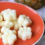 Pineapple Pupsicles frozen dog treats shaped like paw print on orange plate