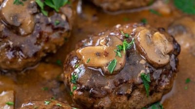 sailbury steak in pan smothered with mushroom gravy