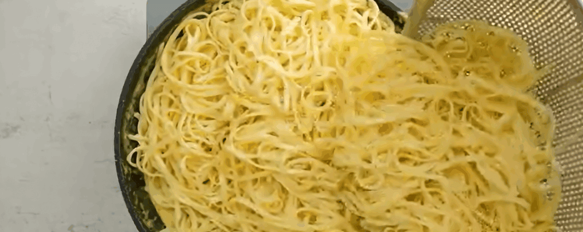 Adding the pasta to the sauce.