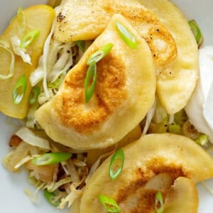 overhead picture of pan fried pierogi on top of sauteed cabbage and apples