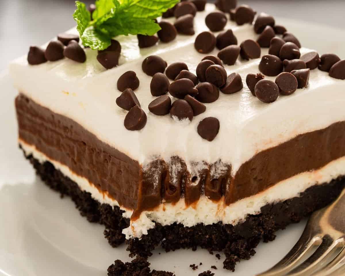 Slice of chocolate lasagna on a white plate with a fork.