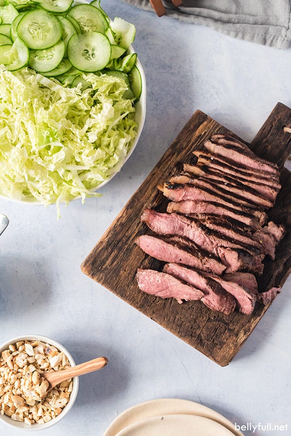 overhead of sliced grilled steak on cutting board