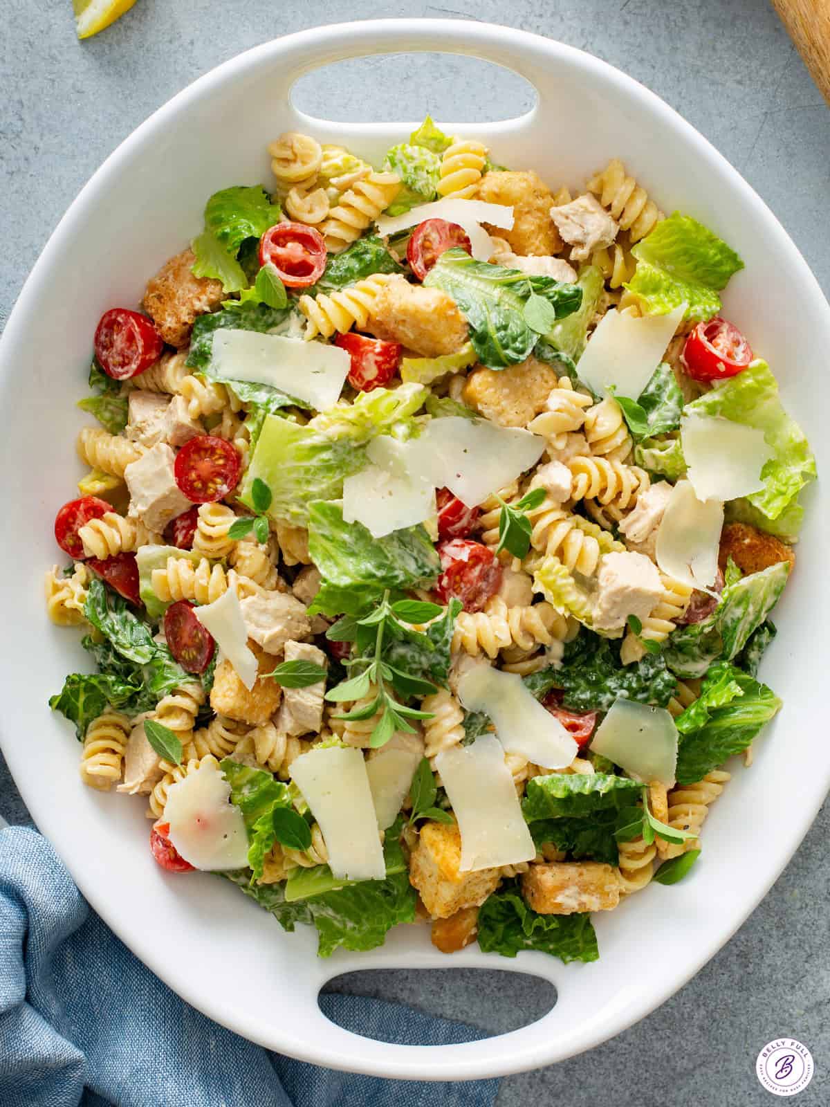 Chicken Caesar pasta salad in a white serving bowl.