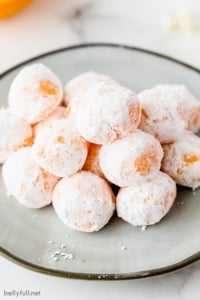 mound of powdered sugar coated orange chocolate truffles on plate