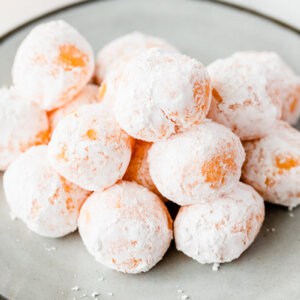 mound of powdered sugar coated orange chocolate truffles on plate