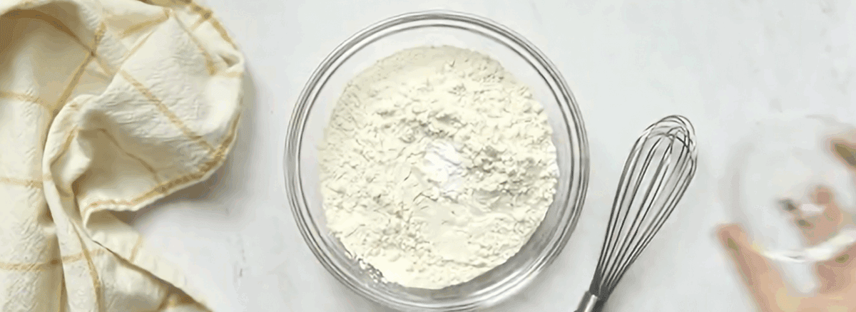 Combining dry ingredients in a glass bowl.