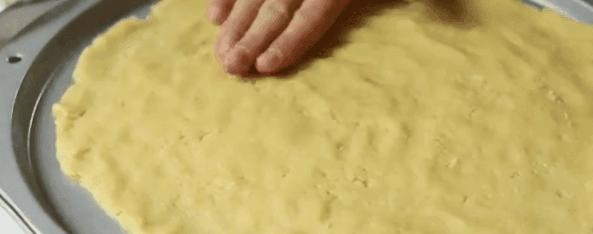 Flattening dough into a pie plate.