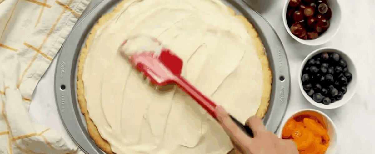 Spreading the topping over the crust.
