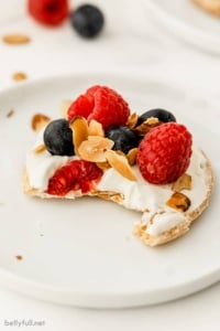 close up of mini raspberry and blueberry fruit tart with bite taken