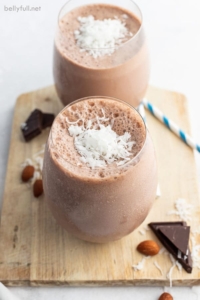 almond joy smoothie in short glass with shredded coconut on top