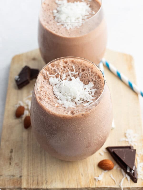 almond joy smoothie in short glass with shredded coconut on top