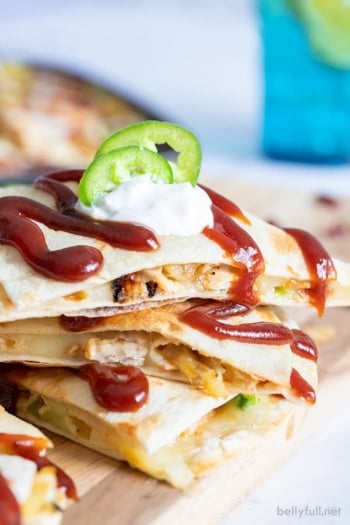 3 stacked quesadilla wedges with barbecue sauce and sour cream