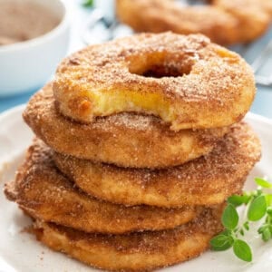 stack of 5 pineapple fritter rings with bite taken from top one