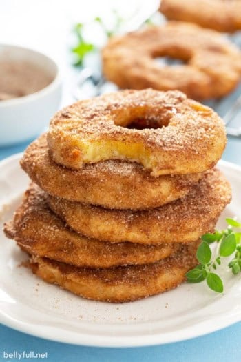 stack of 5 pineapple fritter rings with bite taken from top one