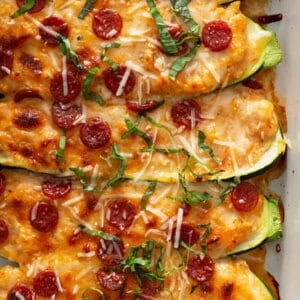 close up of 5 baked zucchini halves stuffed pizza toppings