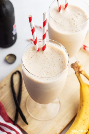 banana smoothie in glass with two straws