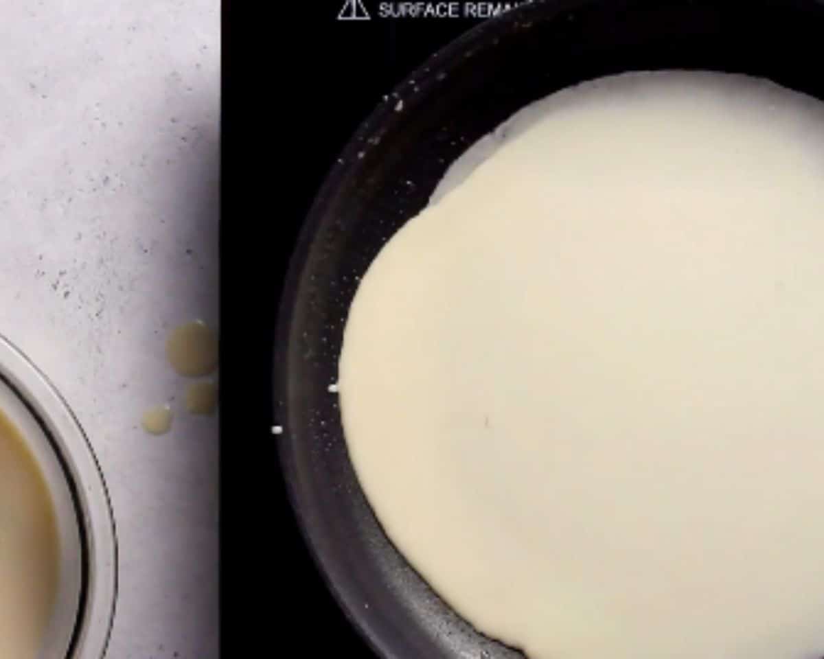 Blini batter poured into a hot pan and spreading to the edges