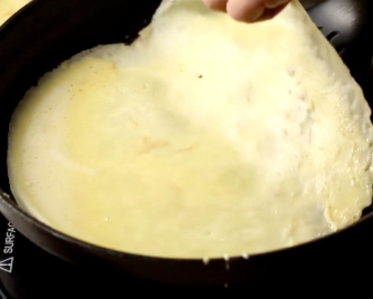 Swirling blini batter in the pan to form a thin, even crepe