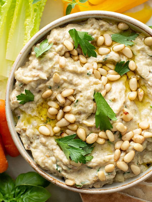 overhead of baba ganoush in dish with toasted pine nuts