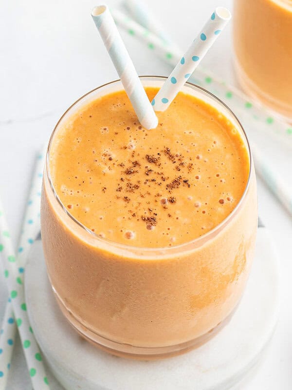 carrot cake smoothie in glass with two straws