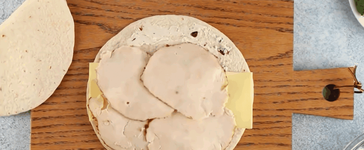 Layering chicken slices over the cheese.