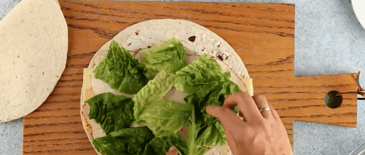 Adding romaine lettuce over the chicken.