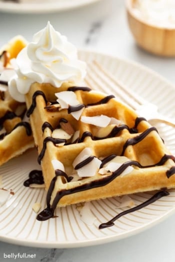 close up of waffles section drizzled with chocolate sauce on plate