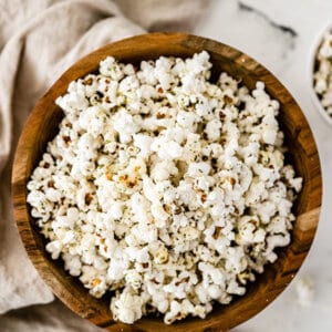 overhead of garlic bread popcorn in wooden bowl with brown napkin