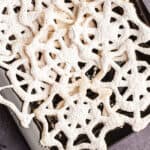 closeup overhead of black serving tray filled with spiderweb cookies