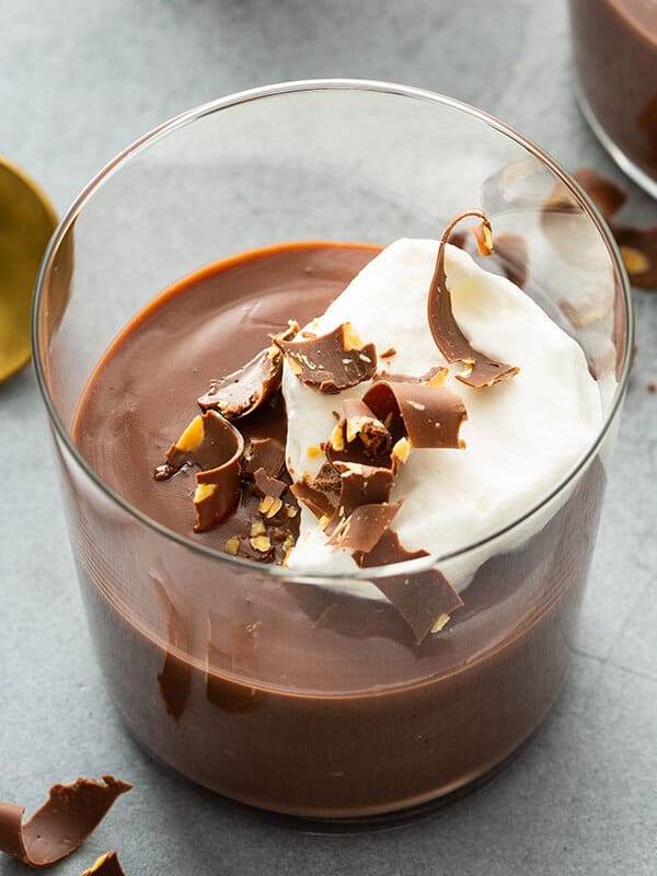 chocolate pudding in cup with whipped cream and chocolate shavings