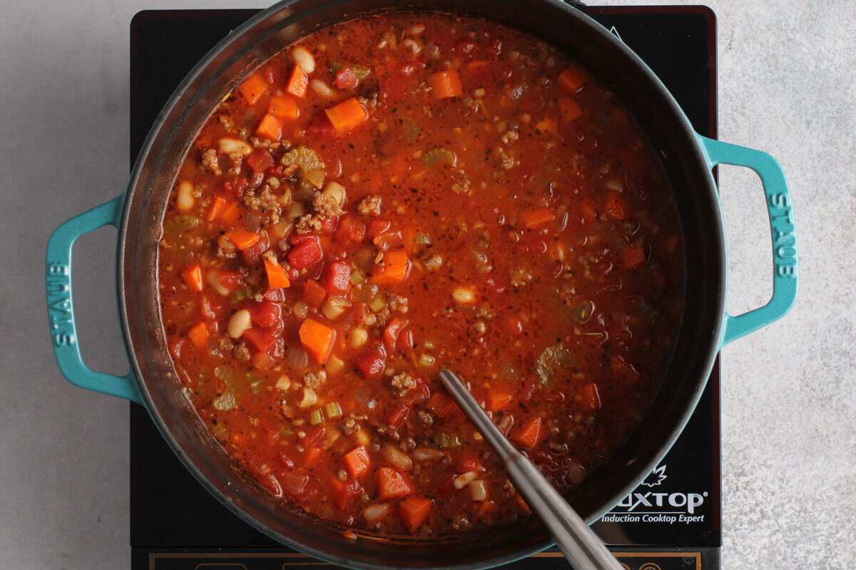 Adding liquid ingredients and seasonings to the pot.