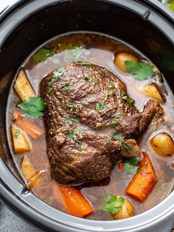 cooked chuck roast in crock pot with vegetables