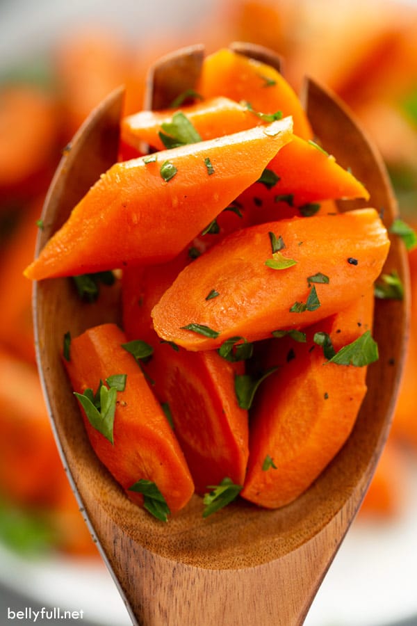 close up of roasted carrots on wooden spoon